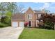 Charming two-story brick home with a well-manicured lawn, mature trees, and an attached two-car garage at 3025 Kaley Nw Dr, Kennesaw, GA 30152