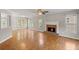 Inviting living room featuring hardwood floors, a brick fireplace, and large windows that fill the room with light at 3025 Kaley Nw Dr, Kennesaw, GA 30152