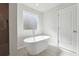 Luxurious bathroom with a modern soaking tub, stylish fixtures, and a window for natural light at 358 Orwell Dr, Social Circle, GA 30025