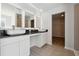 Bathroom featuring dual vanity sinks, illuminated mirrors, and wood-look tile floors at 358 Orwell Dr, Social Circle, GA 30025