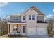 Charming two-story home with a brick facade, covered porch, two-car garage and professionally landscaped yard at 358 Orwell Dr, Social Circle, GA 30025