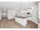 Bright kitchen with a granite island, white cabinets, stainless steel appliances, and modern lighting at 358 Orwell Dr, Social Circle, GA 30025