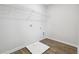 Bright laundry room with wood floors, utility connections, and a wire shelf at 358 Orwell Dr, Social Circle, GA 30025