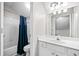 Bright bathroom with a white vanity, toilet, tub and a blue shower curtain at 1483 Chamirey Sw Dr, Marietta, GA 30008