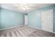 A bright bedroom with two entry doors, ceiling fan, blue paint, and grey carpeting at 1483 Chamirey Sw Dr, Marietta, GA 30008