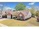 Lovely home featuring brick accents, green lawn, and mature trees in a well-maintained neighborhood at 1483 Chamirey Sw Dr, Marietta, GA 30008