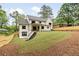 A stunning, modern farmhouse features a backyard with a grassy lawn and fresh landscaping at 1501 Harts Mill Ne Rd, Brookhaven, GA 30319