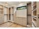 Custom walk-in closet with wood shelving, drawers, and a window providing natural light at 1501 Harts Mill Ne Rd, Brookhaven, GA 30319