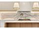 Kitchen backsplash features custom marble slab and gold pot filler at 1501 Harts Mill Ne Rd, Brookhaven, GA 30319
