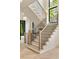Elegant staircase with modern black railings, hardwood steps, and a large window providing natural light at 1501 Harts Mill Ne Rd, Brookhaven, GA 30319