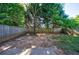 Large, private backyard featuring a wooden fence, mature trees, and grassy area at 3226 Saville Sw St, Atlanta, GA 30331