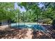 Fully fenced basketball court surrounded by mature trees and landscaping providing shade at 3226 Saville Sw St, Atlanta, GA 30331