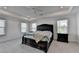 Spacious bedroom with a large tufted headboard bed, tray ceiling with ceiling fan, and multiple windows at 5530 Bower Pl, Cumming, GA 30028