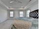 Bright bedroom featuring a tray ceiling with fan, carpet, and a large bed with a tufted headboard at 5530 Bower Pl, Cumming, GA 30028
