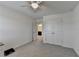 Bedroom with light gray carpet featuring neutral walls, fan, closet and doorways to other rooms at 5530 Bower Pl, Cumming, GA 30028