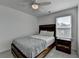 Bedroom with a stylish bed, ceiling fan, and a nightstand illuminated by natural light from the window at 5530 Bower Pl, Cumming, GA 30028