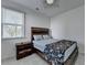 Bright bedroom with large window and ceiling fan featuring a wooden bed frame at 5530 Bower Pl, Cumming, GA 30028