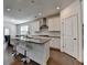 Open kitchen boasts a gray center island with stainless appliances and a view into the dining space at 5530 Bower Pl, Cumming, GA 30028