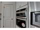 Bright kitchen featuring stainless steel double ovens and a side-by-side refrigerator at 5530 Bower Pl, Cumming, GA 30028