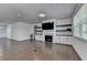Sun-filled living room with hardwood floors, fireplace, built-ins, and a large window offering natural light at 5530 Bower Pl, Cumming, GA 30028