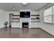 Bright living room features a fireplace with marble surround and custom built-ins with floating shelves at 5530 Bower Pl, Cumming, GA 30028