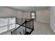 Bright airy loft space offering a view of the neighborhood through a window and a dark brown bannister at 5530 Bower Pl, Cumming, GA 30028