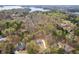 Aerial view of property line; a blue two-story home surrounded by lush greenery with lake in the background at 7636 Chestnut Hill Rd, Cumming, GA 30041