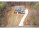 Aerial view of a blue two-story home with a gray roof and a long, winding white driveway at 7636 Chestnut Hill Rd, Cumming, GA 30041