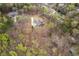Aerial view of property line; a blue two-story home surrounded by lush greenery with lake in the background at 7636 Chestnut Hill Rd, Cumming, GA 30041