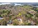 Aerial view of property line; a blue two-story home with lake in the background surrounded by lush greenery at 7636 Chestnut Hill Rd, Cumming, GA 30041