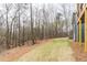 Wide backyard with mature trees and a gentle slope, offering potential for landscaping at 7636 Chestnut Hill Rd, Cumming, GA 30041