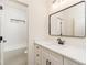 Modern bathroom featuring a sleek vanity with black hardware and a contemporary mirror at 7636 Chestnut Hill Rd, Cumming, GA 30041