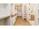 Large walk-in closet with custom shelving and a view to the bathroom at 7636 Chestnut Hill Rd, Cumming, GA 30041