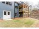 Back exterior featuring a covered deck, large windows, and a well-maintained lawn at 7636 Chestnut Hill Rd, Cumming, GA 30041
