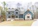 Beautiful two-story home featuring a charming exterior, landscaped yard, and elegant architectural details at 7636 Chestnut Hill Rd, Cumming, GA 30041