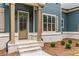 Close-up of the front entrance showcasing a wooden door, brick accents, and stylish shutters at 7636 Chestnut Hill Rd, Cumming, GA 30041