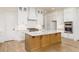 Modern kitchen with stainless steel appliances, wooden island, and white cabinetry at 7636 Chestnut Hill Rd, Cumming, GA 30041