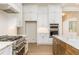 Kitchen with white cabinets, stainless appliances, marble countertops and wood island at 7636 Chestnut Hill Rd, Cumming, GA 30041