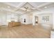 Open-concept living space with coffered ceilings flowing into a modern kitchen and natural light at 7636 Chestnut Hill Rd, Cumming, GA 30041