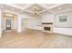 Open living room with hardwood floors, fireplace, and seamless flow to other living spaces at 7636 Chestnut Hill Rd, Cumming, GA 30041