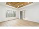 Bedroom featuring tray ceilings, a large window and a barn door to the en suite at 7636 Chestnut Hill Rd, Cumming, GA 30041