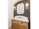 Stylish powder room features custom vanity with marble countertop, designer mirror, and sconces at 7636 Chestnut Hill Rd, Cumming, GA 30041