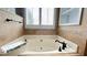 Large soaking tub with tiled backsplash, black hardware, and storage at 223 Cheatham Rd, Acworth, GA 30101