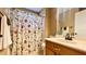 Bathroom featuring a floral shower curtain, wood vanity, decorative mirror and neutral walls at 223 Cheatham Rd, Acworth, GA 30101