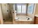 Bathroom features large soaking tub, glass shower, and window at 223 Cheatham Rd, Acworth, GA 30101