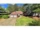 Charming brick home featuring a two-car garage, lush lawn, and mature trees at 223 Cheatham Rd, Acworth, GA 30101