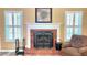 Cozy fireplace with a brick surround and a decorative mantel, flanked by windows with shutters at 223 Cheatham Rd, Acworth, GA 30101