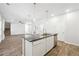 Contemporary kitchen island with dark granite countertops, stainless steel appliances, and bright pendant lighting, perfect for cooking at 232 Orwell Dr, Social Circle, GA 30025