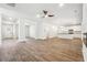 Spacious living area with hardwood floors, ceiling fan, and open layout leading to a modern kitchen, ideal for entertaining at 232 Orwell Dr, Social Circle, GA 30025