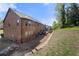 Large backyard featuring a brick house, multiple windows, patio, and lush greenery at 2745 Veltre Sw Ter, Atlanta, GA 30311